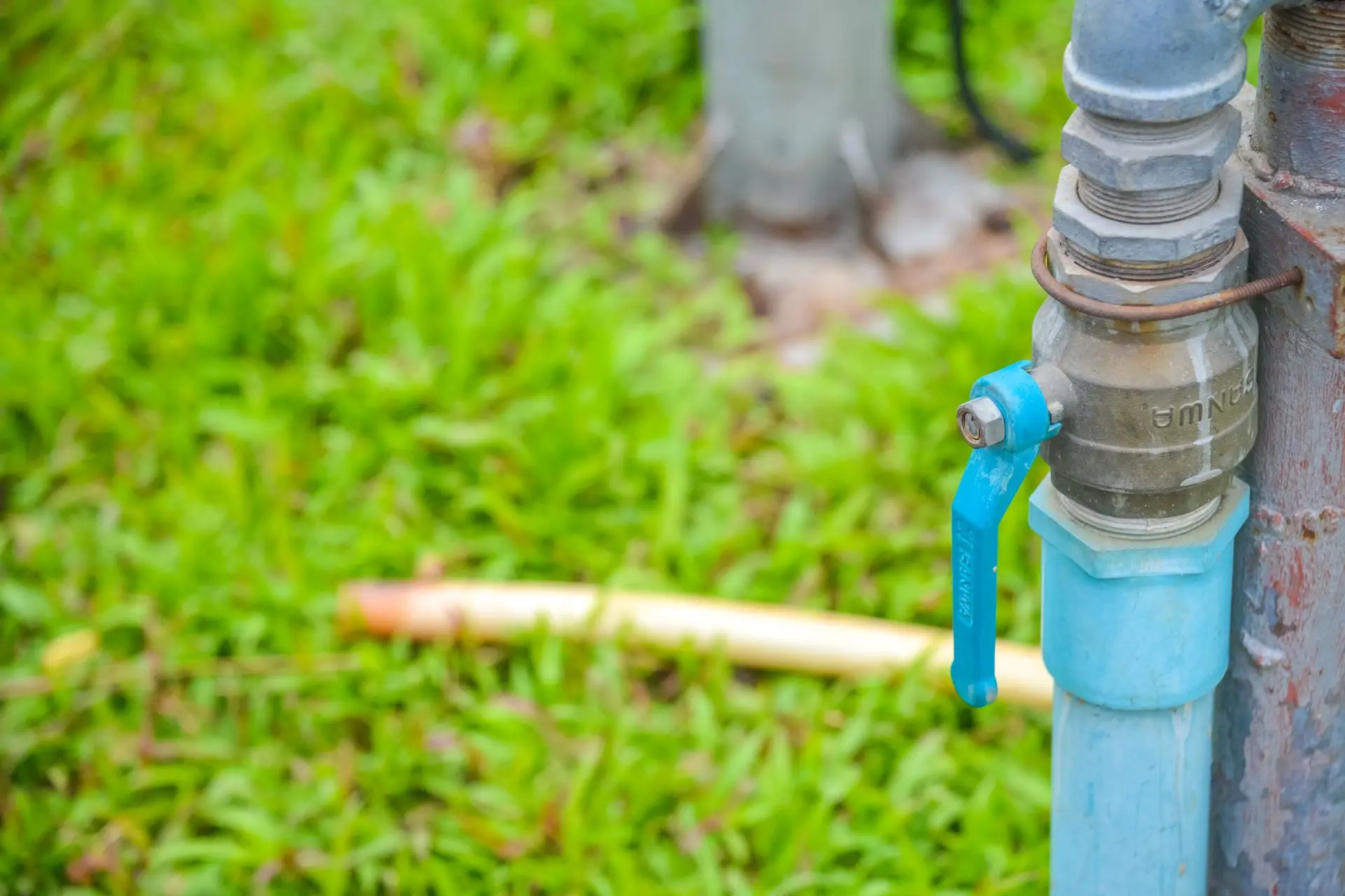 Blue-handled valve on a borehole supply line